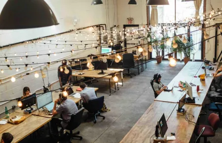 Man at communal desk in large office space | How to get a promotion