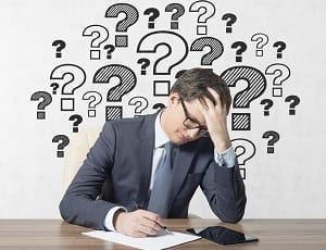 Businessmen working in office with drawing question mark on wall